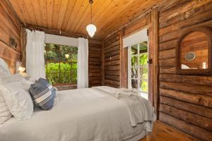 a bedroom with a bed in a log cabin at Restdown Kangaroo Valley in Barrengarry