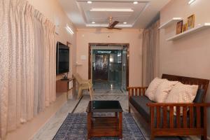 un soggiorno con divano e TV di Katyayani Serenity - Your Premium Homestay a Bhadrachalam