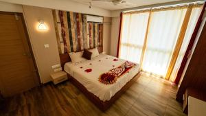 a bedroom with a bed and a large window at Hilton Cloud Resort in Wayanad