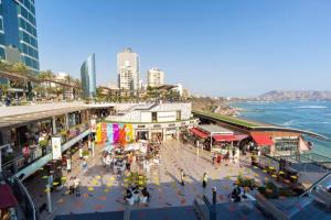 een uitzicht over een stad met mensen en de oceaan bij Lujoso Departamento de Estreno en la mejor zona de Barranco in Lima