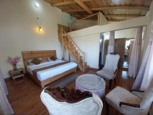 1 dormitorio con 1 cama, escalera y sillas en Anmol paradise en Mukteswar
