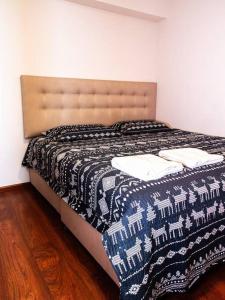 1 dormitorio con 1 cama con manta blanca y negra en Lujoso Departamento de Estreno en la mejor zona de Barranco en Lima
