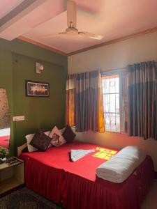 a bedroom with a large red bed with a window at Relax Zone in Patna