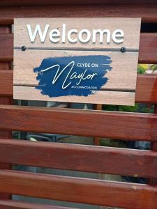 a welcome sign on the back of a wooden bench at Clyde on Naylor in Clyde
