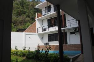 una casa blanca con una piscina frente a ella en El Rincón Preferido, en Papantla de Olarte