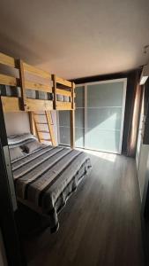 a bedroom with a bunk bed and a large window at maison 3 chambres avec piscine in Calvi