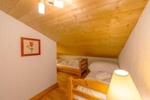 Camera mansardata con 2 letti e una lampada. di 3 chambres - Plan des Reines - Happy Rentals a Chamonix-Mont-Blanc