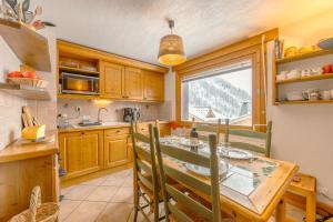 une cuisine avec une table à manger et une fenêtre dans l'établissement 3 chambres - Plan des Reines - Happy Rentals, à Chamonix-Mont-Blanc