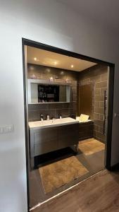 uma casa de banho com um lavatório e um espelho em maison 3 chambres avec piscine em Calvi