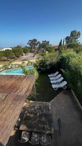uma vista sobre um pátio com cadeiras e uma piscina em maison 3 chambres avec piscine em Calvi
