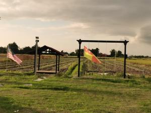 two flags flying in a field next to a fence at Panorama Indah Homestay in Sungai Besar