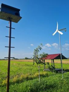 a wind turbine and a house in a field at Panorama Indah Homestay in Sungai Besar