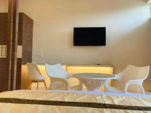 a table and chairs with a television on a wall at TLS- The Lavish Stay in Varanasi
