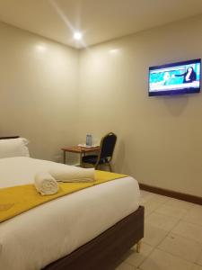 a hotel room with a bed and a tv on the wall at 7 Days Holiday Inn in Nairobi
