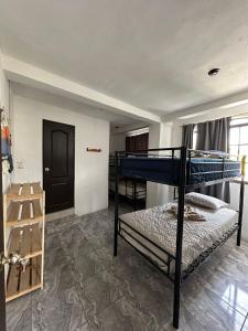 um quarto com 2 beliches e uma porta em 4 Elementos Hostal em San Juan La Laguna