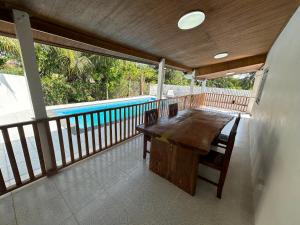 a deck with a wooden table and a swimming pool at Pool villa copacolanta with 2 motorbikes for free in Ko Lanta