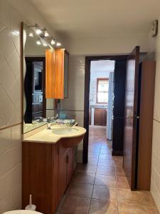 een badkamer met een wastafel en een spiegel bij Relax House & Garden in Santa Luria