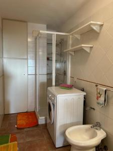 een badkamer met een wasmachine en een toilet bij Relax House & Garden in Santa Luria
