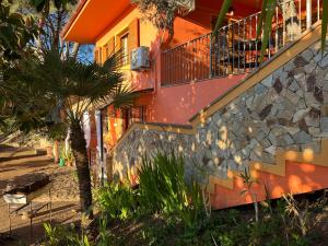 een huis met een balkon en een palmboom bij Relax House & Garden in Santa Luria