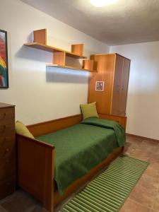 een slaapkamer met een bed met een groen dekbed bij Relax House & Garden in Santa Luria