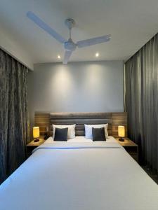 1 dormitorio con 1 cama blanca grande y 2 lámparas en Sky stay, en Noida