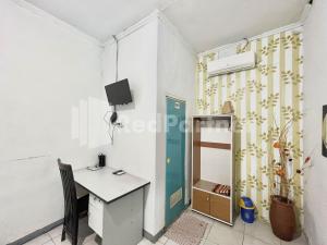 a room with a desk and a tv on the wall at Lafa Park Syariah Rengas Bandung Cikarang Redpartner in Glonggong