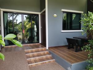 a house with stairs and a table and windows at Oscar Villa Aonang Krabi - Free Shuttle Bus to The Beach in Ao Nang Beach