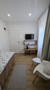 a bedroom with a bed and a couch and a tv at Aurelia Rooms in Mostar