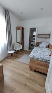 a bedroom with a bed and a chair at Aurelia Rooms in Mostar