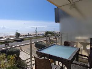 uma varanda com uma mesa e vista para a praia em Appartement Saint-Jean-de-Monts, 2 pièces, 4 personnes - FR-1-323-255 em Saint-Jean-de-Monts