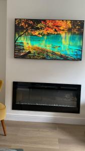a television hanging on a wall above a fireplace at Beautiful 58 sqm Apartment Zone 2 in London