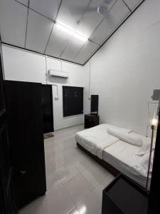 a white room with a bed and a tv at Pondok Baba in Kota Bharu +11 photos