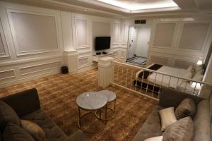 een woonkamer met een bank, een bed en een tafel bij The Grantage Hotel & Sky Lounge in Serpong