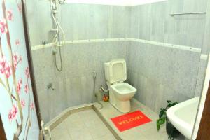 a bathroom with a shower and a toilet and a sink at The Bunker in Badulla