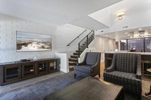 een woonkamer met 2 stoelen en een trap bij Stylish and Modern Park Ave Condo, Swimming Pool, 5 minutes to Main in Park City