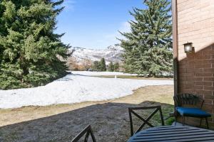 een patio met een tafel en stoelen en een sneeuwbedekt veld bij Stylish and Modern Park Ave Condo, Swimming Pool, 5 minutes to Main in Park City