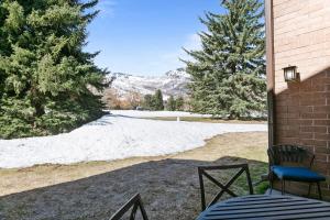 a patio with a table and chairs and a snow covered field at Stylish and Modern Park Ave Condo, Swimming Pool, 5 minutes to Main in Park City