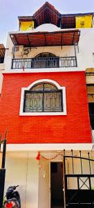 - un bâtiment en briques rouges avec une fenêtre au-dessus dans l'établissement Budget Private Ac Room with Kitchen Near Osho Garden, à Pune