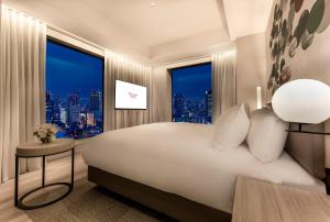 a bedroom with a large bed with a large window at Centara Grand Hotel Osaka in Osaka