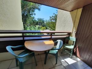 stół i krzesła na balkonie z oknem w obiekcie Appartement Lumineux à Seignosse, Proche Plage, Commerces et Activités, Parking, Wifi et Balcon - FR-1-239-813 w mieście Seignosse