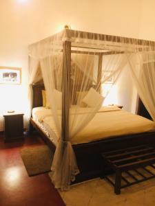 a bedroom with a bed with a canopy at Colonial Residence Kandy in Kandy