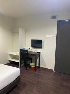 um quarto com uma secretária, um computador e uma cama em 1st inn hotel subang em Subang Jaya
