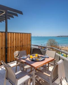 a table and chairs on a balcony with a view of the beach at Hotel Nafpaktos in Nafpaktos