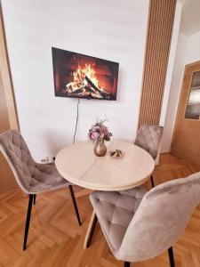 una mesa y sillas con chimenea en una habitación en CENTAR, en Brčko