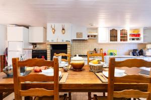 - une cuisine avec une table et des chaises en bois dans l'établissement l'Oeil de Carcassonne, à Caudebronde
