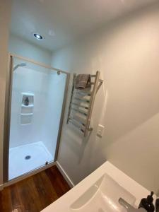 a bathroom with a sink and a towel rack at Sunny Modern Cottage - Close to Airport in Napier