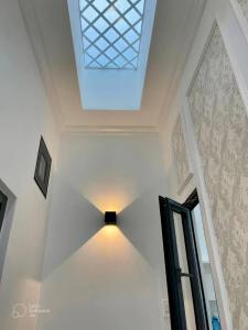 uma luz de tecto num quarto branco com uma janela em HANSUN Home - Rạch Giá em Rạch Giá