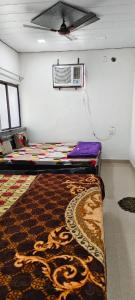 een kamer met een tapijt en airconditioning aan de muur bij Priya Prem peeth guest house ⁰ in Vrindāvan