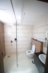 a bathroom with a shower and a toilet and a sink at ROYAL RESIDENCY in Kānnangād
