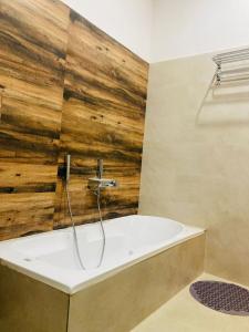 y baño con bañera y pared de madera. en TLS- The Lavish Stay, en Varanasi